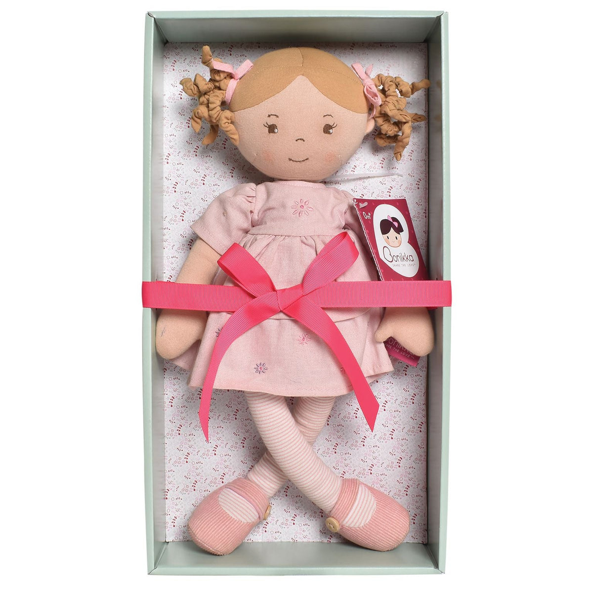 Hellbraunhaarige Stoffpuppe im rosa Leinenkleid