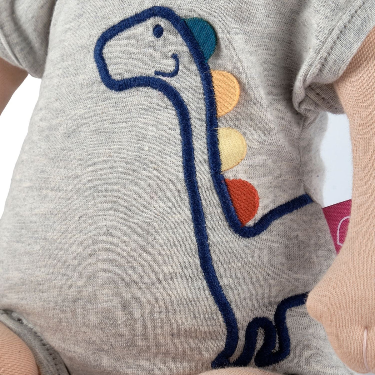 Poupée douce bio en pyjama dinosaure et bonnet jaune