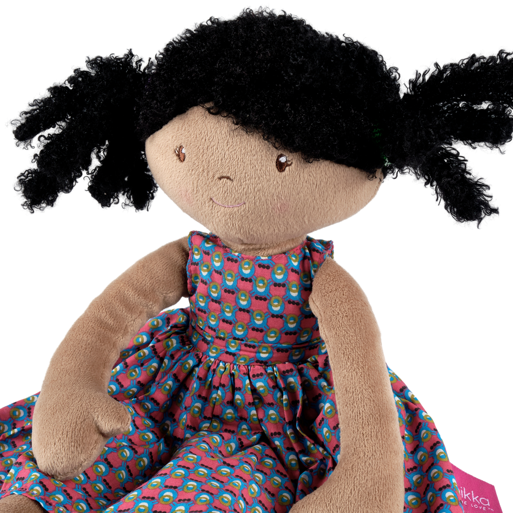 Schwarze Stoffpuppe mit lockigem Haar in einem lila Baumwollkleid